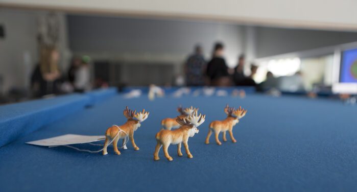 Small moose figures on a blue table.