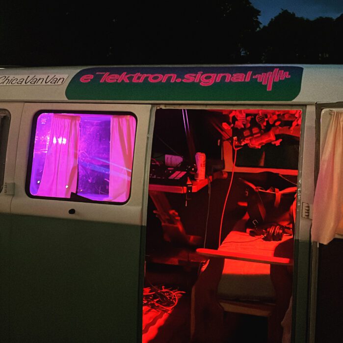 A doorway to a van. Lighted red and pink inside the van.