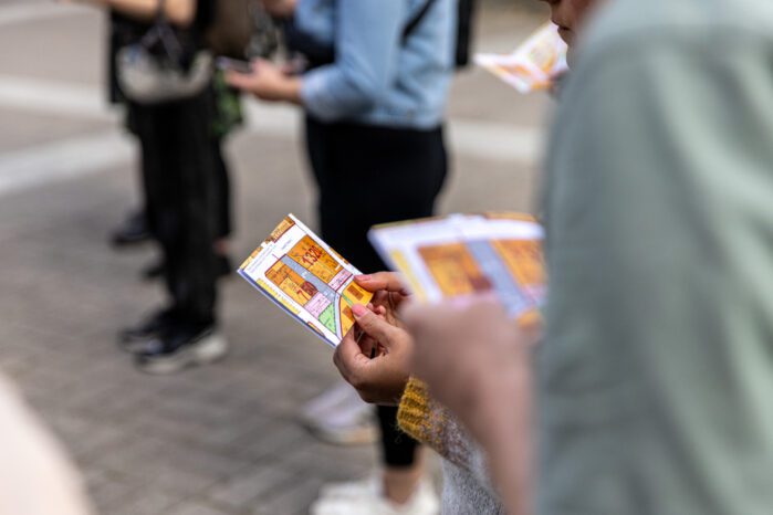 Human figures holding brochures in their hands.