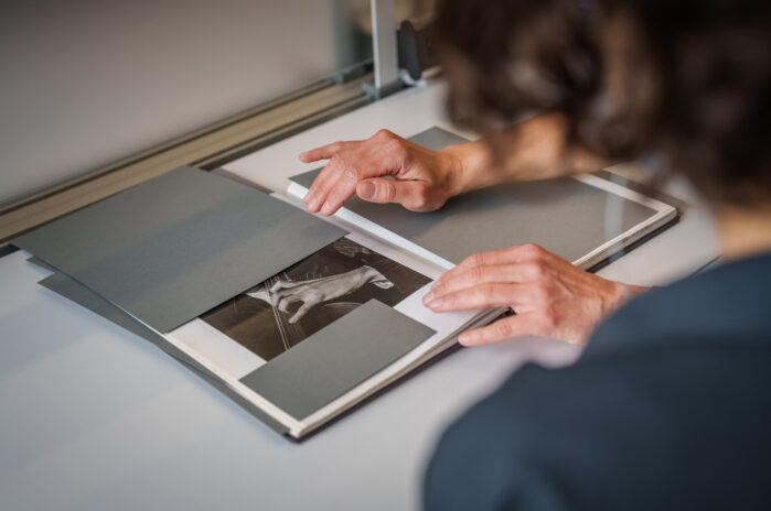 Human hands presenting a book to another person.